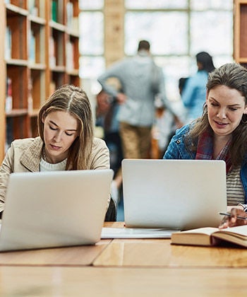 mensen werken op laptops in een bibliotheek