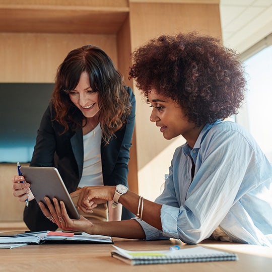 twee vrouwelijke collega's werken met een tablet