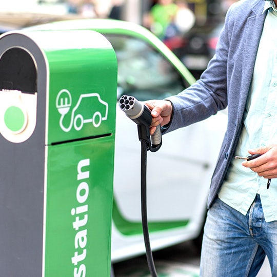 man bij een laadpunt voor elektriciteit