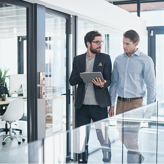 collega bespreekt informatie op tablet met collega