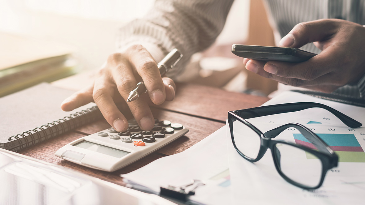 man working on a calculator 