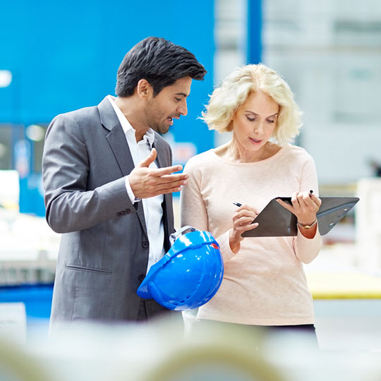 collega's bekijken een laptop in een magazijn
