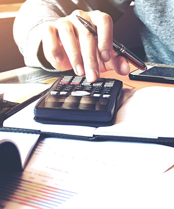 close up van een hand die met een calculator werkt