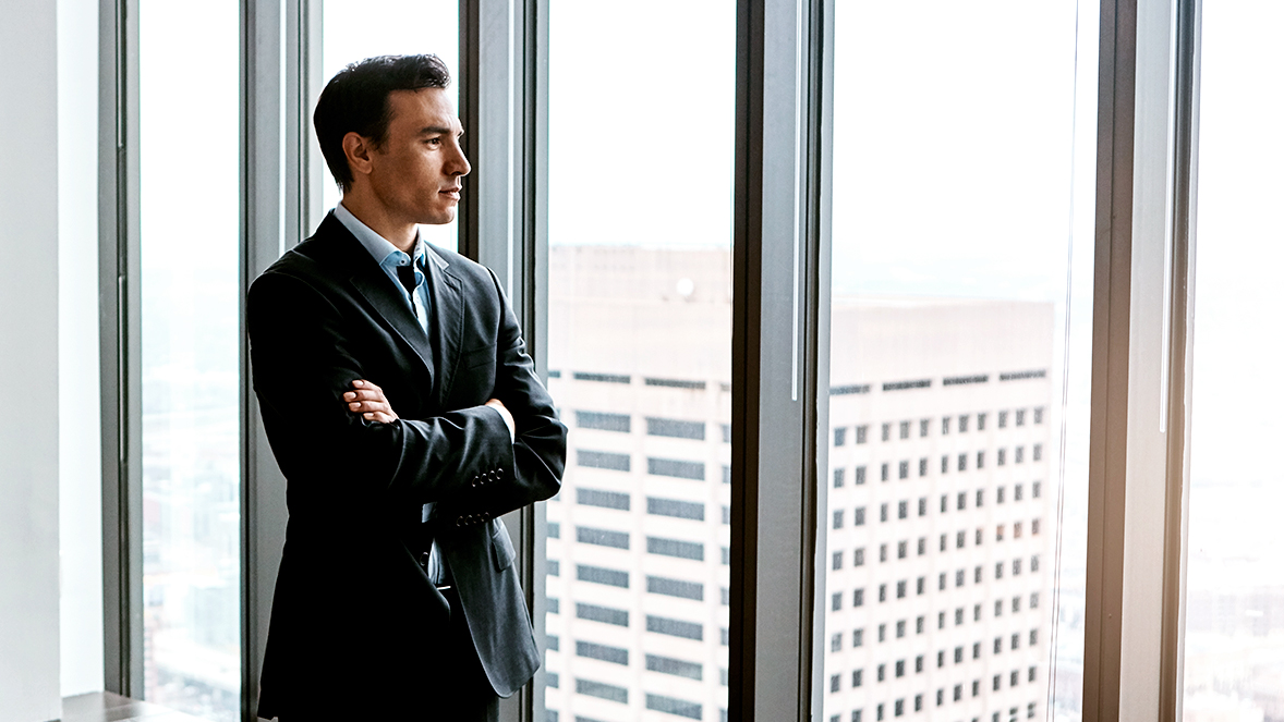 zakenman die uit het raam kijkt in een kantoorgebouw