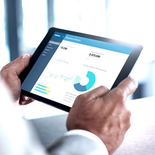 Maak gebruik van de voordelen van automatisering close up of hands holding a tablet showing a graph