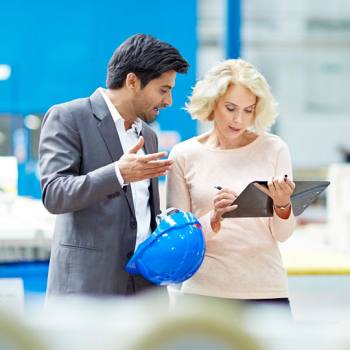 collega's bekijken een laptop in een magazijn