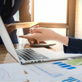 hand wijst naar een laptop