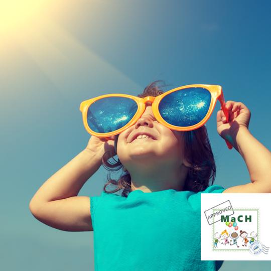 Stichting Make a Child Happy Kind met grote zonnebril die naar de zon kijkt